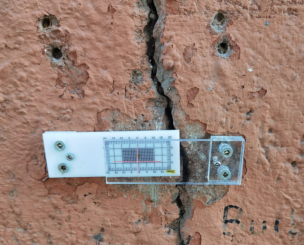 Fisurómetro instalado sobre una grieta en un muro de fábrica
